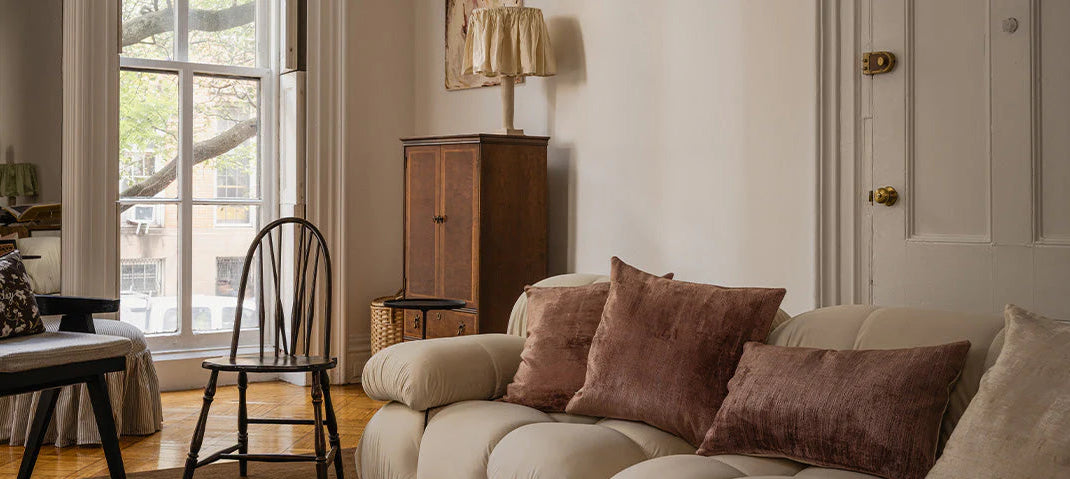 Living room with a beige sofa, brown cushions, and a wooden cabinet.