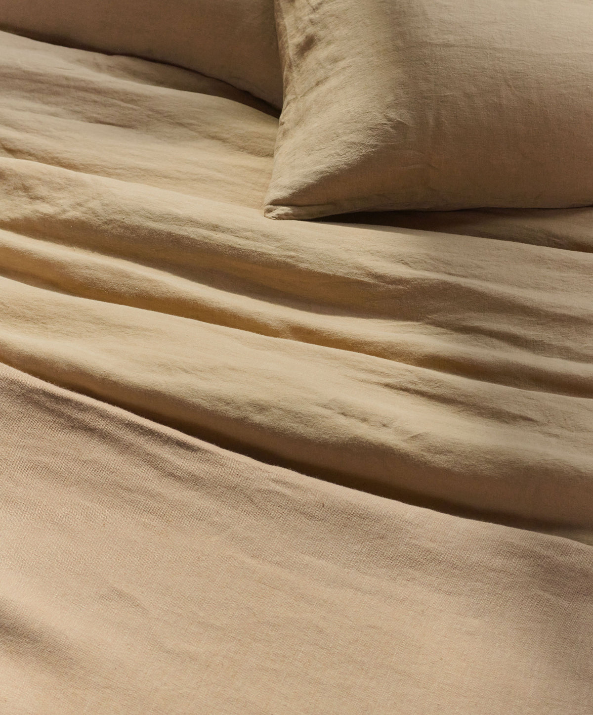 Beige bedding set with a pillow on a bed