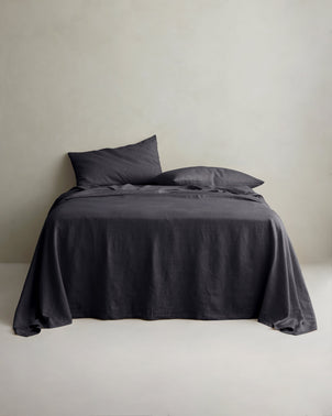 Slate linen sheet set with pillowcases from CULTIVER, styled on a bed, showcasing soft, textured bed linen for a cozy bedroom look.