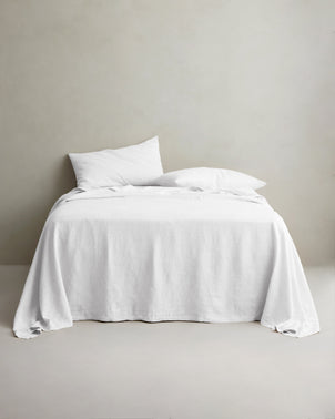 White linen sheet set with pillowcases from CULTIVER styled on a bed, showcasing soft, breathable bed linen for a cozy bedroom look.