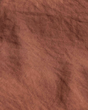 Introducing the Complimentary Swatch - Sienna: a brown linen sample with visible texture and subtle creases, creating a soft, uneven surface. The earthy, warm Sienna color features natural shading variations throughout the material—perfect for fabric samples or sparking inspiration in your home decor projects.