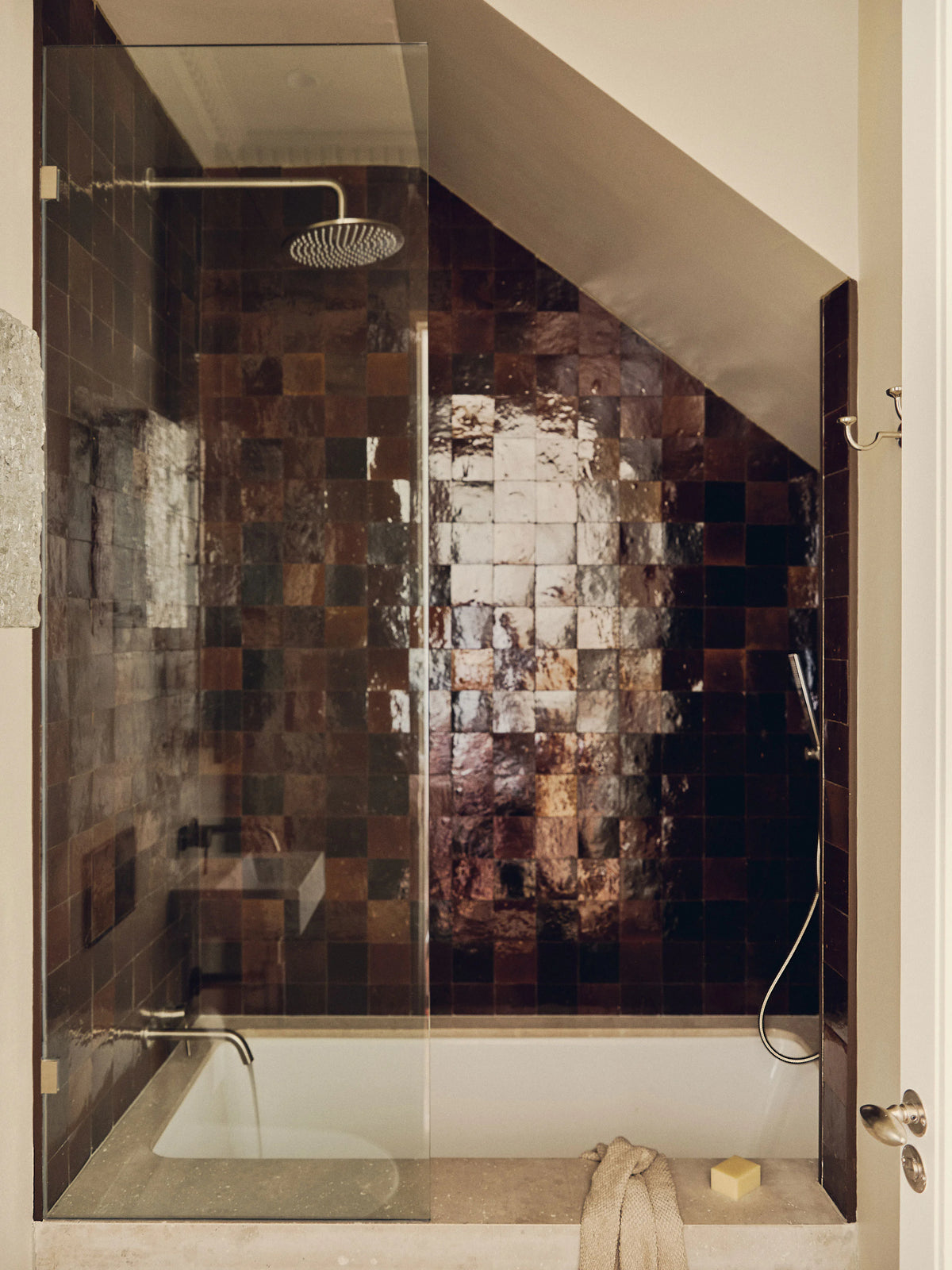 Modern shower with glass enclosure and mosaic tile wall