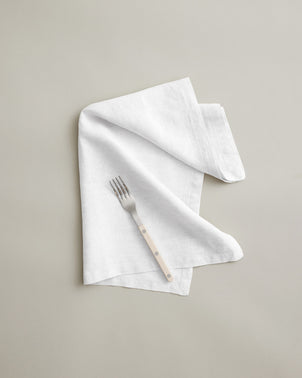 White linen table napkin from CULTIVER, showcasing a soft, elegant fabric fold perfect for sophisticated table settings.