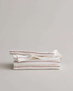 Stack of CULTIVER Linen Table Napkins with Cedar Stripe pattern, soft fabric and elegant design for dining and table setting.