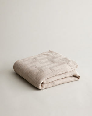 Cultiver Rolfes natural bedcover folded, soft woven bedcover for bedroom decor and comfort.