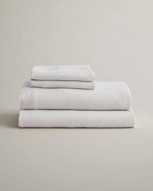 Folded smoke gray linen sheet set with matching pillowcases, made by CULTIVER, showcasing soft, breathable bed linen.