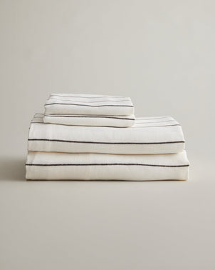 CULTIVER linen sheet set with pillowcases in truffle stripe, folded to showcase soft, durable bed linen fabric.