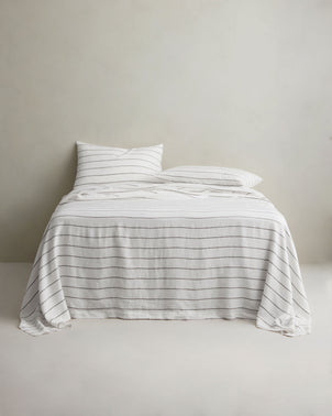 Luxury linen sheet set with pillowcases in Truffle Stripe by CULTIVER, styled on a bed for a cozy, elegant bedroom look.