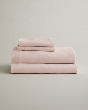 Soft blush linen sheet set with matching pillowcases from CULTIVER, neatly folded for bed linen display.