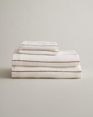 CULTIVER linen sheet set with cedar stripe pattern, including folded bed sheets and pillowcases on a neutral background.
