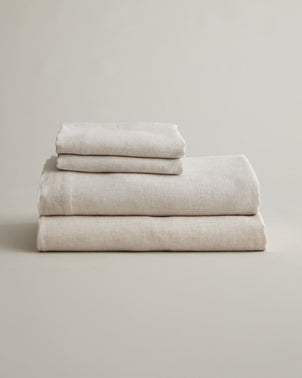 Natural linen sheet set with pillowcases from CULTIVER, folded neatly showcasing soft, breathable bed linen.