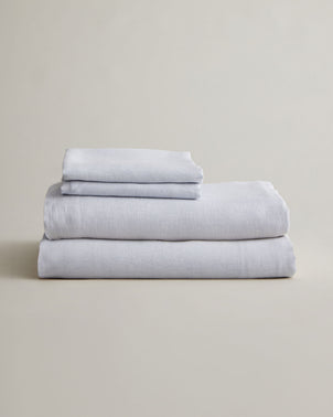 Cultiver sky linen sheet set with pillowcases folded on a bed, showcasing soft, breathable bed linen for a relaxing bedroom look.
