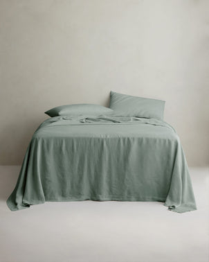 Sage linen bed sheet set with matching pillowcases from CULTIVER, neatly arranged on a bed for a cozy bedroom look.