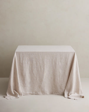 Natural linen tablecloth styled on a dining table, showcasing its lightweight, textured fabric and elegant drape.